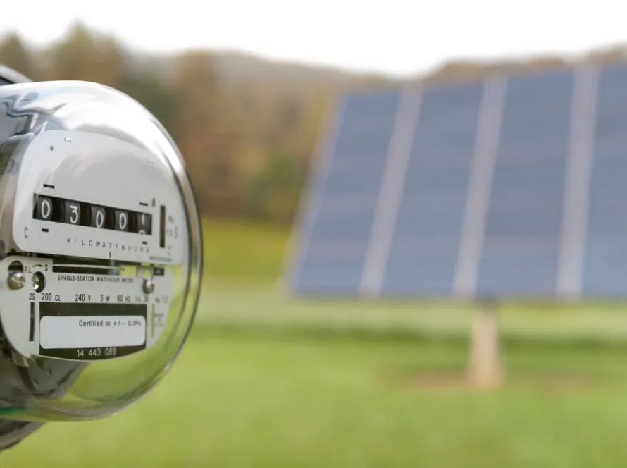 A net meter next to a solar panel.